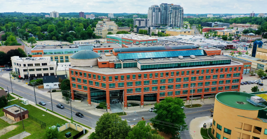 Aerial view of Kitchener-Waterloo cityscape in Ontario showing commercial buildings and surrounding urban area.