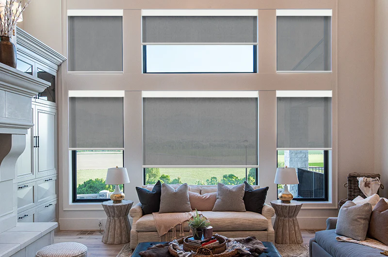 Modern living room with large windows fitted with custom motorized roller blinds in a bright Milton home.