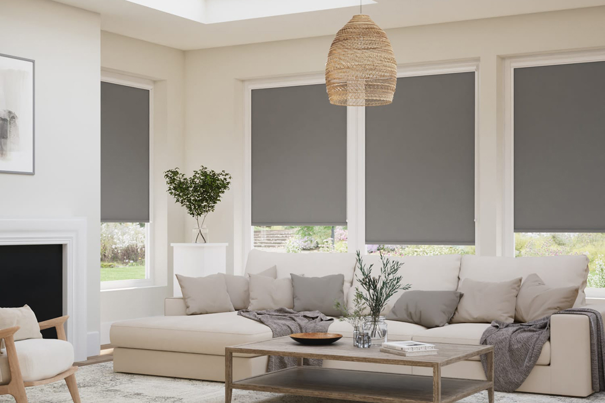 Grey roller blinds fitted on large windows in a bright modern living room