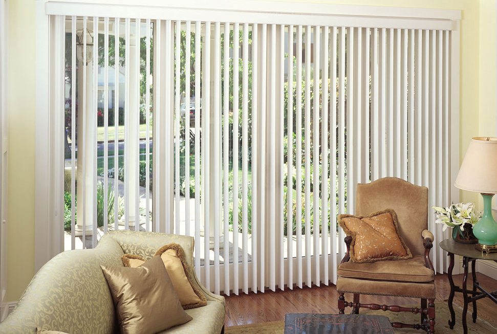 White vertical blinds covering a large sliding glass door in a bright living room